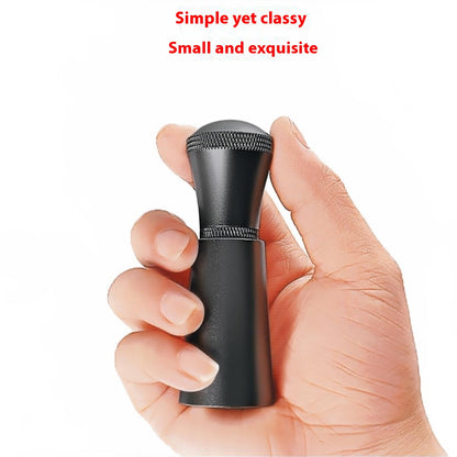 Hand holding the compact black coffee distribution tool to show its size