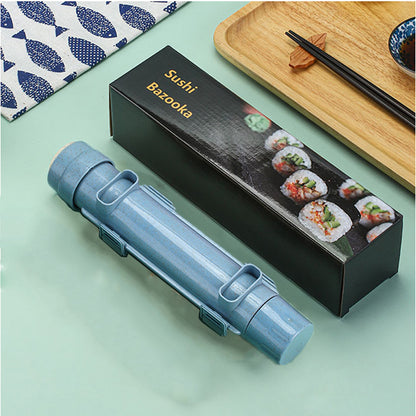 Blue sushi making tool with its Sushi Bazooka packaging box on a green surface
