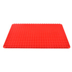 Red pyramid silicone baking mat shown at an angle on a white background, highlighting the raised non-stick texture