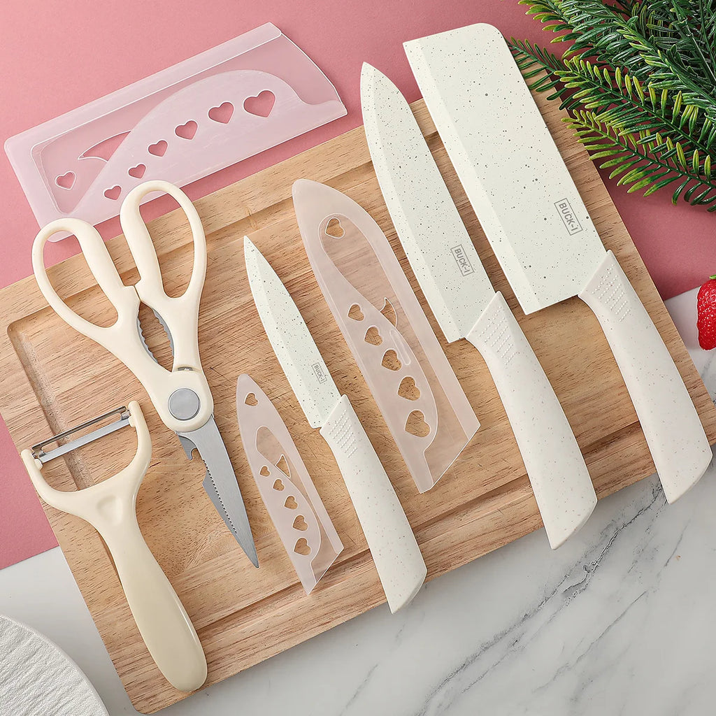 Complete beige knife set with kitchen scissors, peeler, and blade guards on a wood cutting board