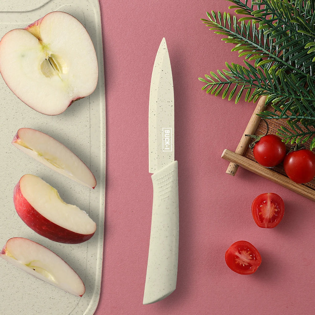 Paring knife next to sliced apple on a cutting board with cherry tomatoes