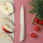 Paring knife next to sliced apple on a cutting board with cherry tomatoes
