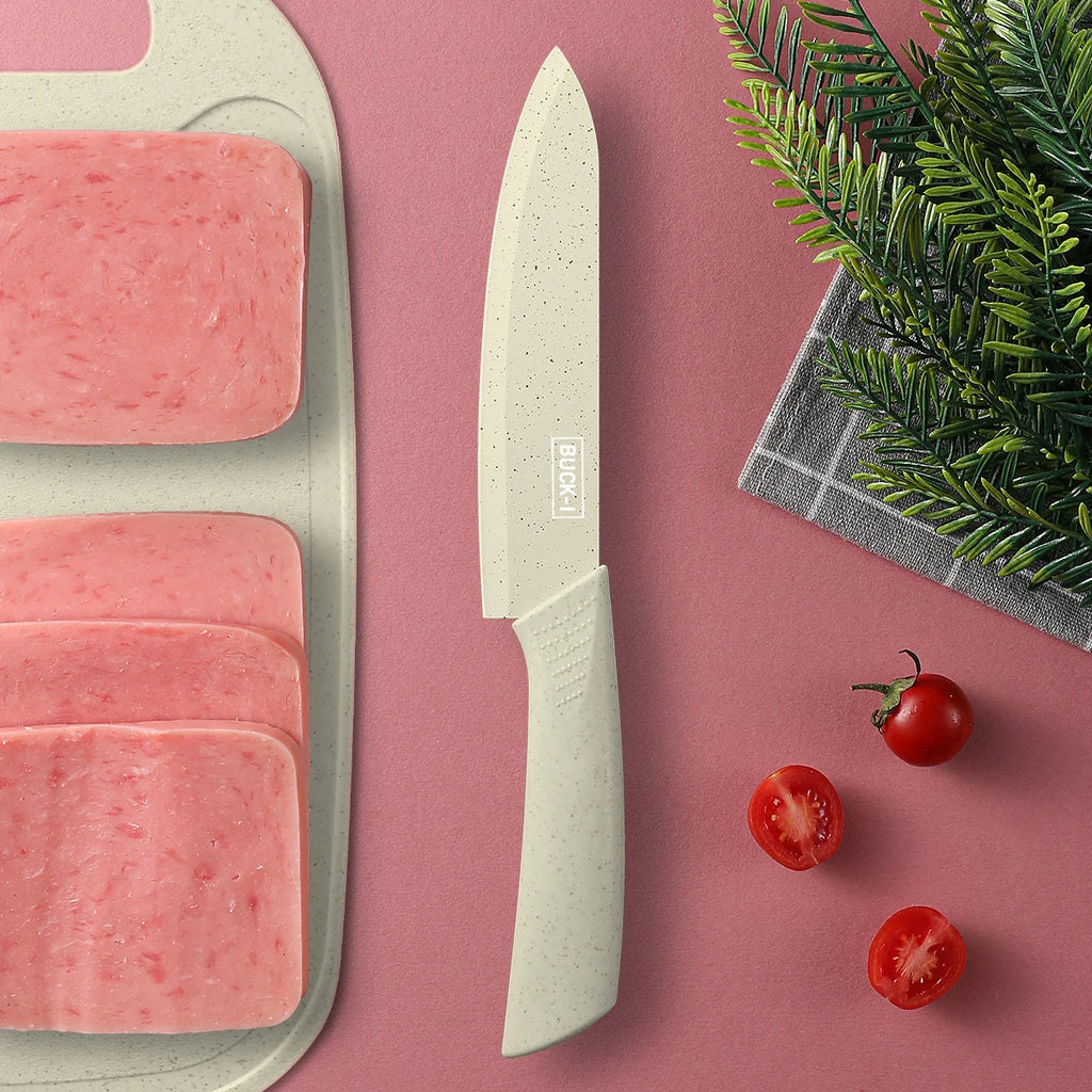 Utility knife beside sliced deli meat on a cutting board with cherry tomatoes