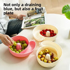 Person picking grapes from a pink snail basket, with cream baskets of cherry tomatoes and berries nearby