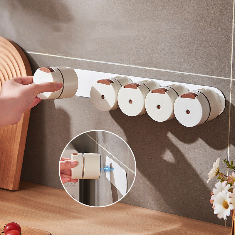 Hand attaching a seasoning canister to a magnetic wall-mounted strip in a kitchen