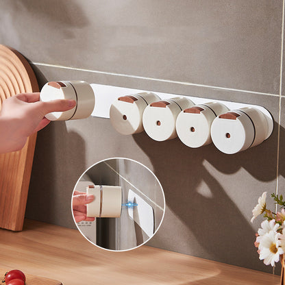 Hand attaching a seasoning canister to a magnetic wall-mounted strip in a kitchen